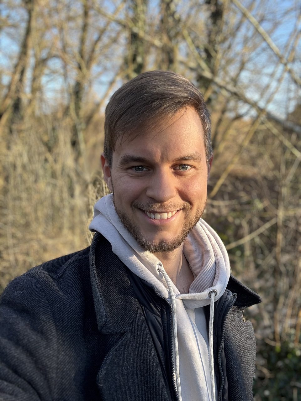 Lukas Babbick draußen im Wald, lachend