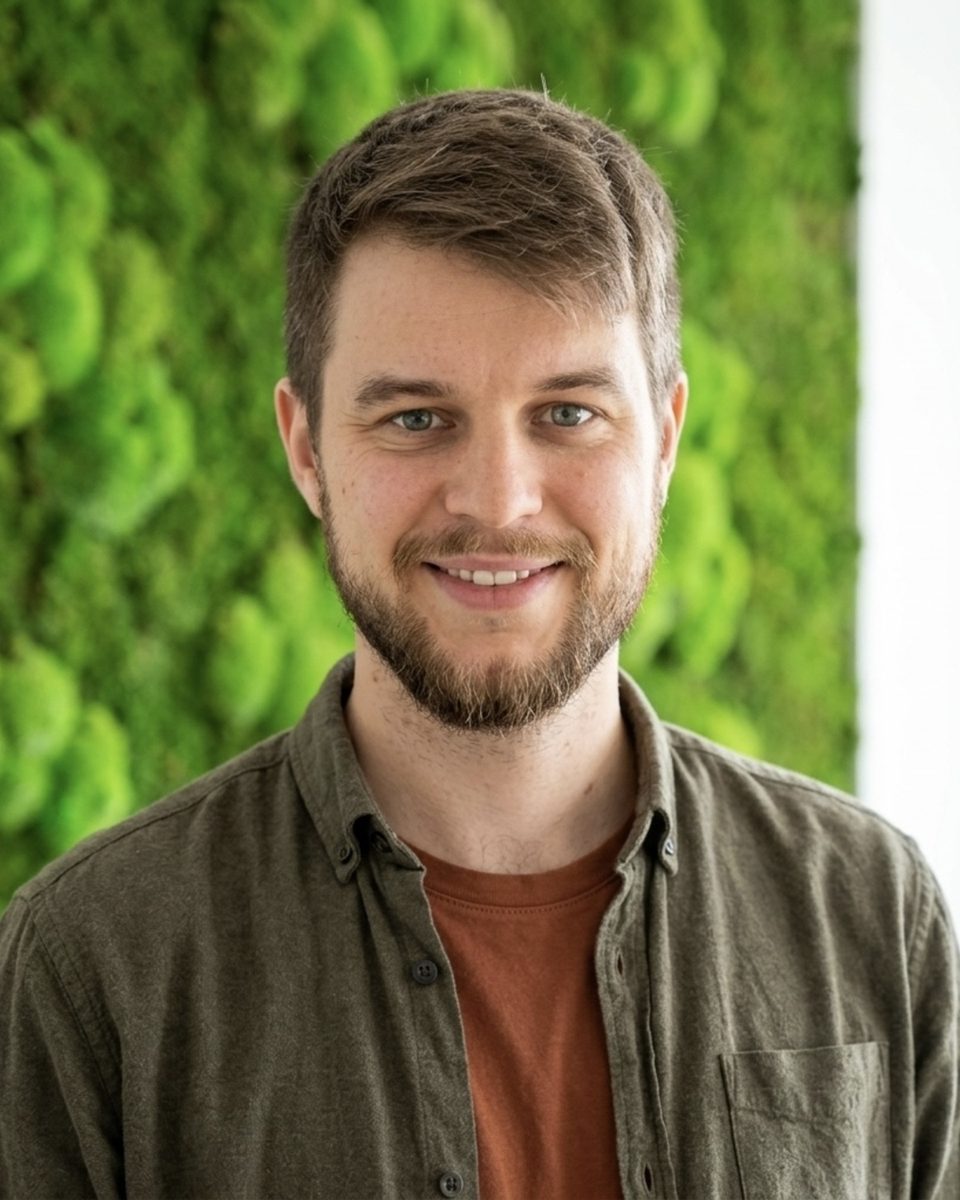 Porträt von Lukas Babbick vor einer Mooswand